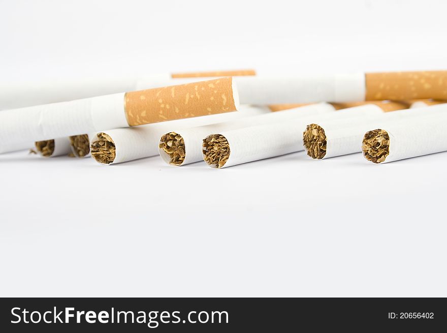 Filter cigarettes scattered on a white ground. Filter cigarettes scattered on a white ground