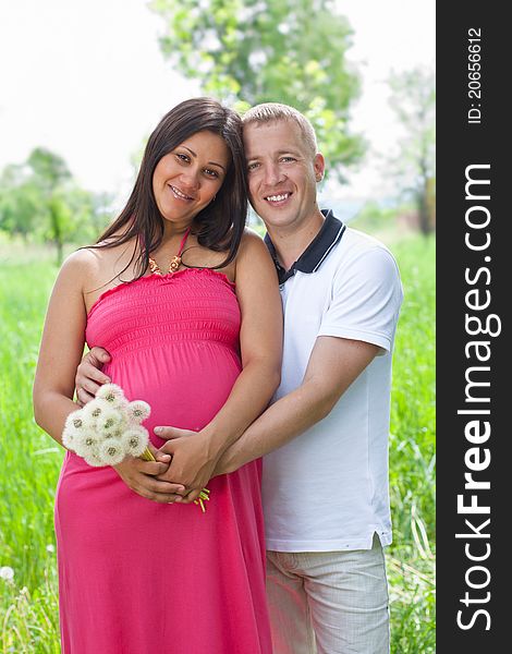 Happy young couple expecting a baby in park