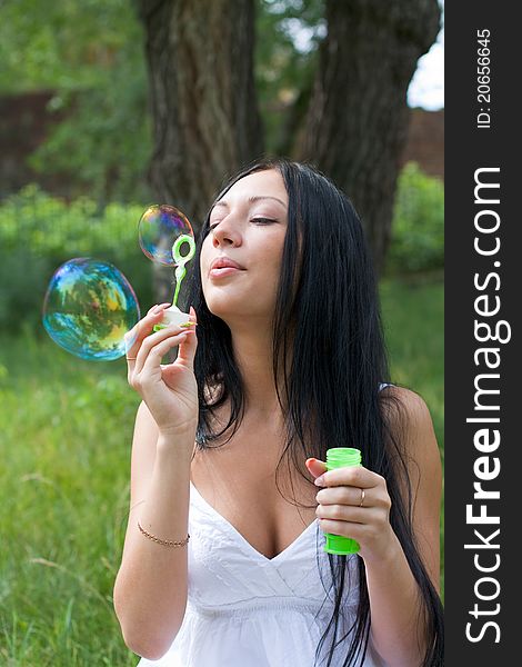 Girl inflates the bubbles in the park