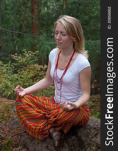 Girl practices yoga in the woods