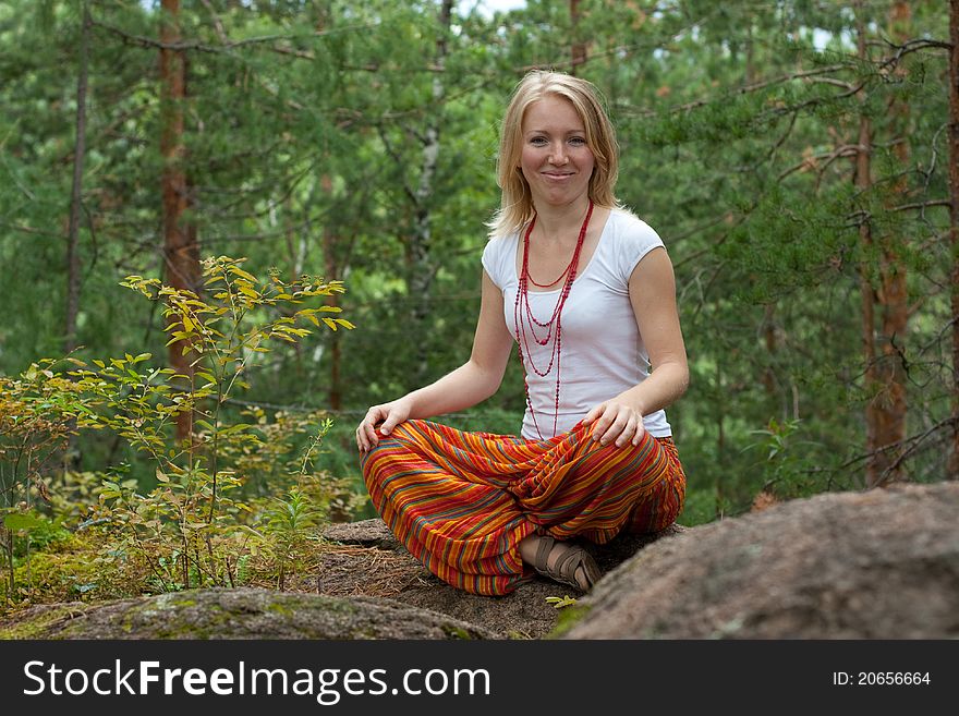 Girl practices yoga in the woods