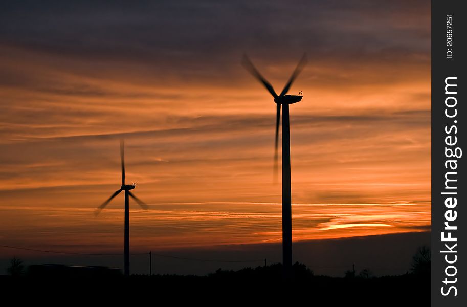 Silhouette of wind power station at sunset