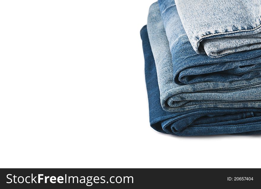 A stack of blue jeans on a white background