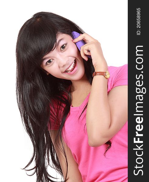 Portrait of young girl laughing during phone call on white background