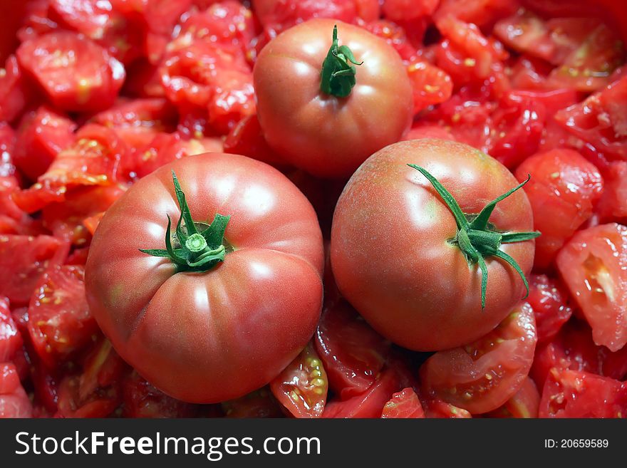 Three tomatoes over chopped tomato mass