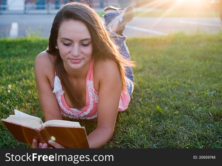 Woman laying down and reading in the twilight of the day. Woman laying down and reading in the twilight of the day.