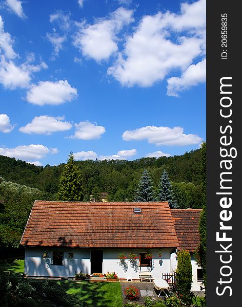 House with red roof and cloudy sky on the background. House with red roof and cloudy sky on the background