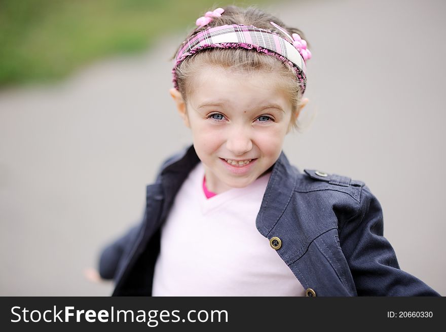 Cute child girl wearing pink headband makes happy smiling face. Cute child girl wearing pink headband makes happy smiling face