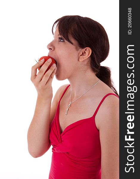 The pretty young woman biting into a tomato. The pretty young woman biting into a tomato