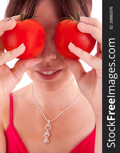 The pretty young woman holding tomatoes in front of the eyes. The pretty young woman holding tomatoes in front of the eyes