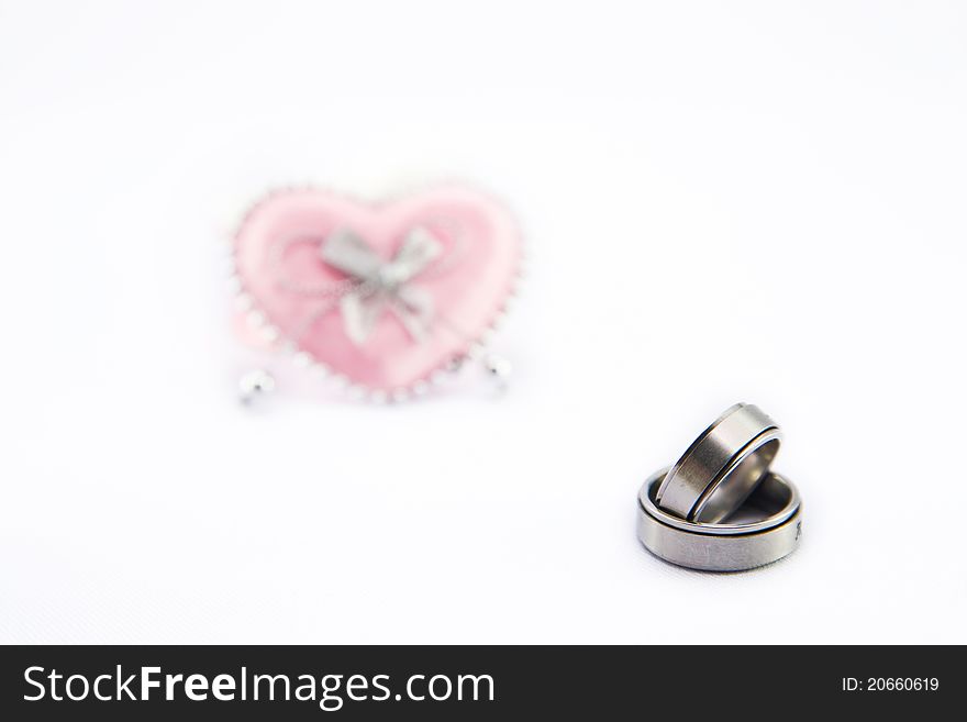 Wedding ring and pink heart isolate on white