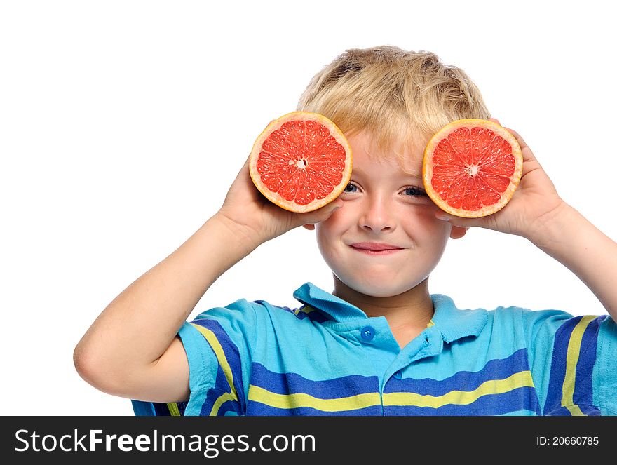 Blond boy covers face with ruby grapefruit; healthy living concept. Blond boy covers face with ruby grapefruit; healthy living concept