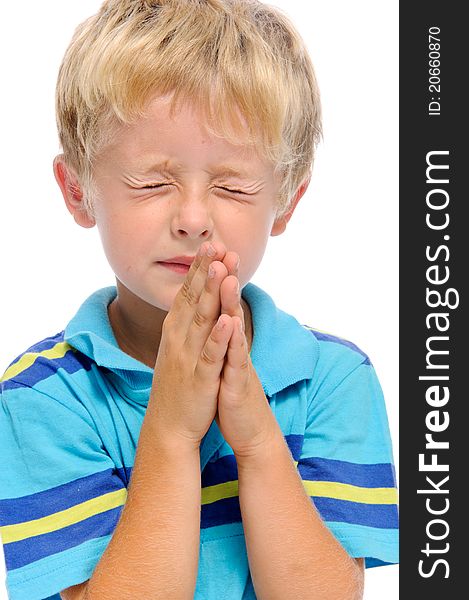 Young blonde child clasps his palms together in prayer, isolated on white. Young blonde child clasps his palms together in prayer, isolated on white