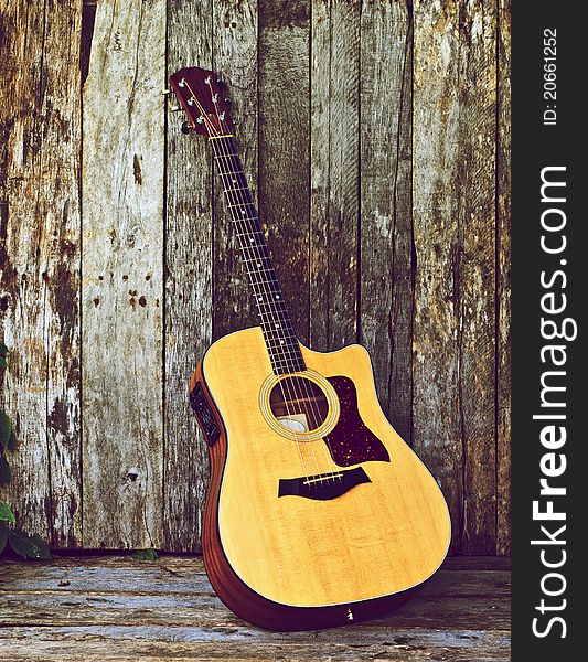 Richly toned image of a classical guitar on a grunge wood backdrop with copy space. Richly toned image of a classical guitar on a grunge wood backdrop with copy space.