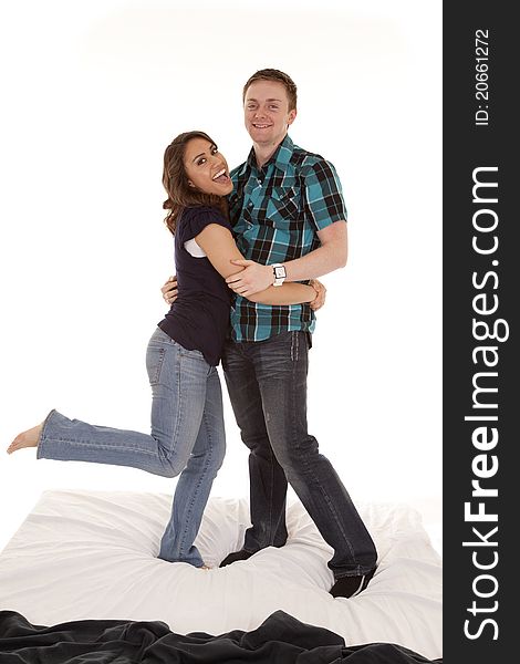 A couple jumping an playing around on the bed. A couple jumping an playing around on the bed.