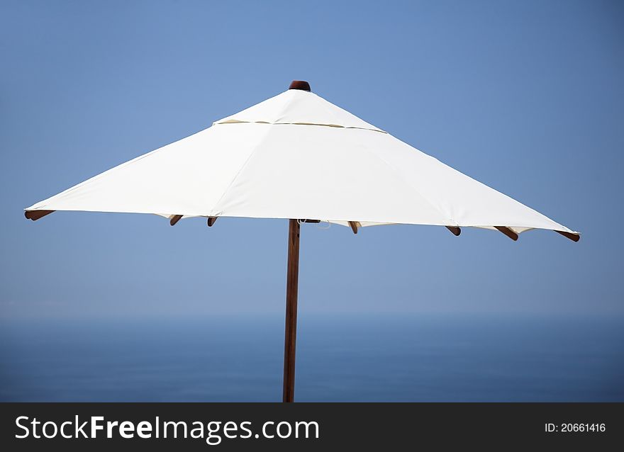 Sun umbrella, and blue natural background of sky and ocean. Sun umbrella, and blue natural background of sky and ocean