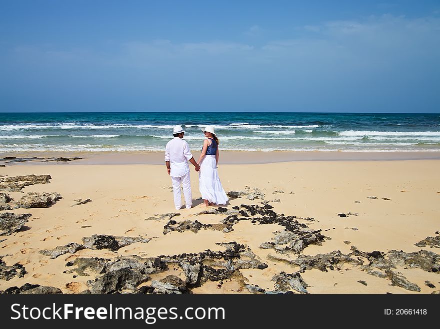 Honeymooners, young couple, standing on a beach, Corralejo, Fuerteventura, Spain. Honeymooners, young couple, standing on a beach, Corralejo, Fuerteventura, Spain
