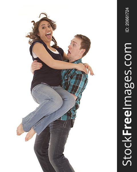 A women jumping into her mens arms with funny expressions on their faces. A women jumping into her mens arms with funny expressions on their faces.