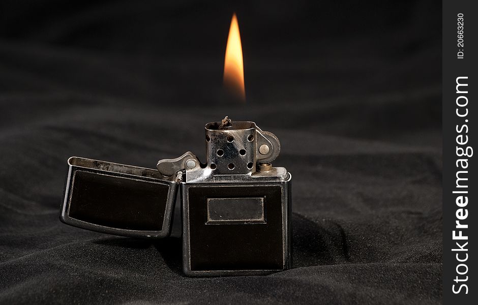 Open flame lighter on black background. Open flame lighter on black background