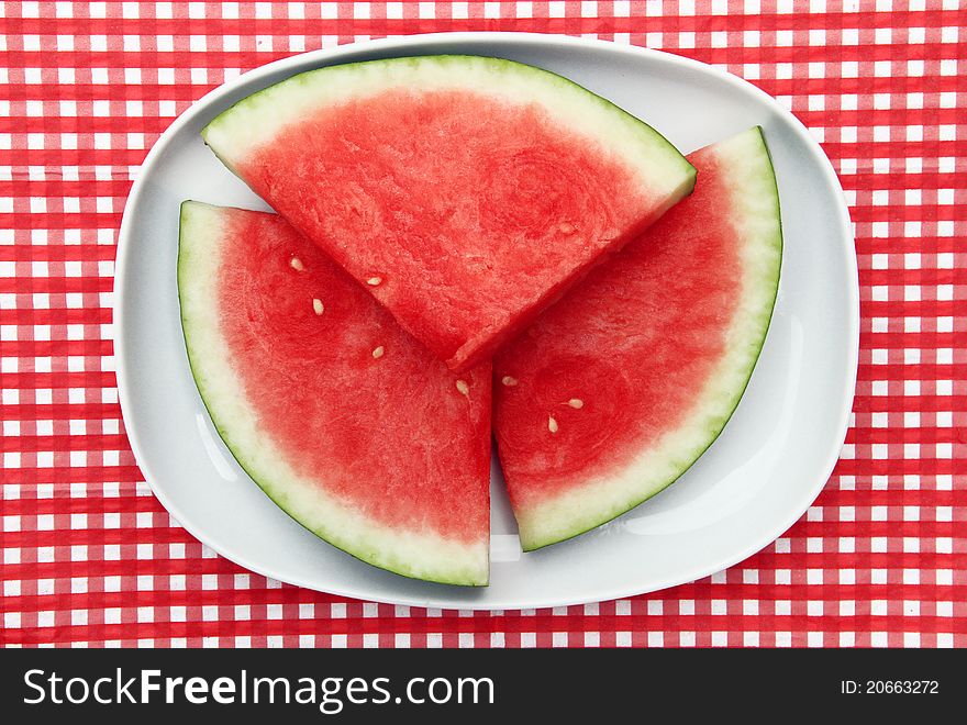 Watermelon Slices on dish on red and white checkered background