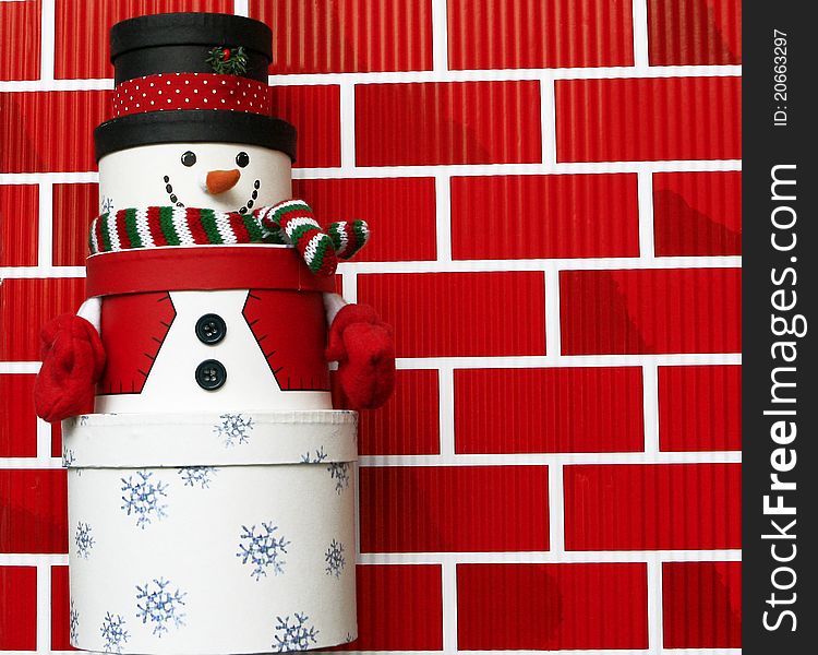 Snowman made of Gift Boxes isolated on red brick wall background