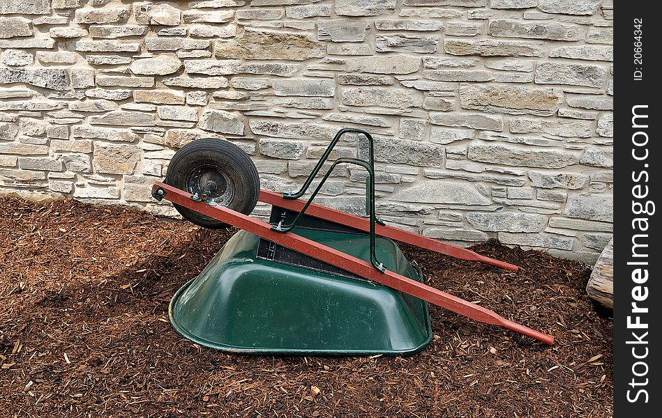 Upturned wheelbarrow against stone wall. Upturned wheelbarrow against stone wall