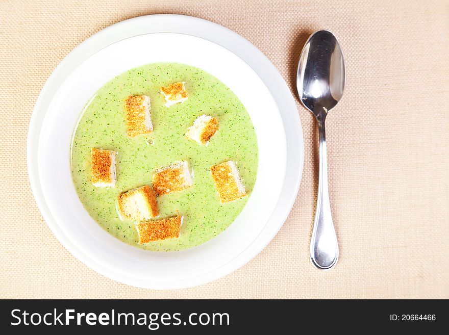 The bowl of broccoli with croutons on the table, top view. The bowl of broccoli with croutons on the table, top view