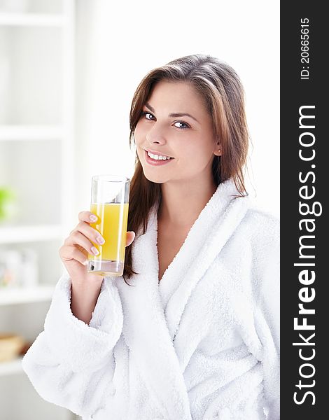 Beautiful girl in a bathrobe with a glass of juice. Beautiful girl in a bathrobe with a glass of juice