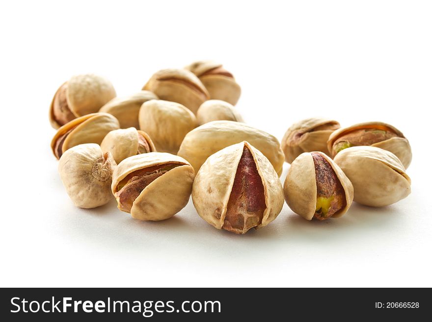 Pile of pistachios is isolated on a white background