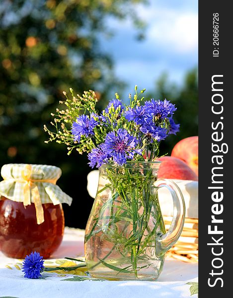 Still life with bouquet of cornflowers with garden as a background. Still life with bouquet of cornflowers with garden as a background.