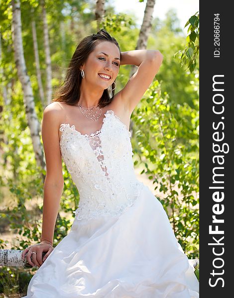 Bride with dark-brown hair posing in forest