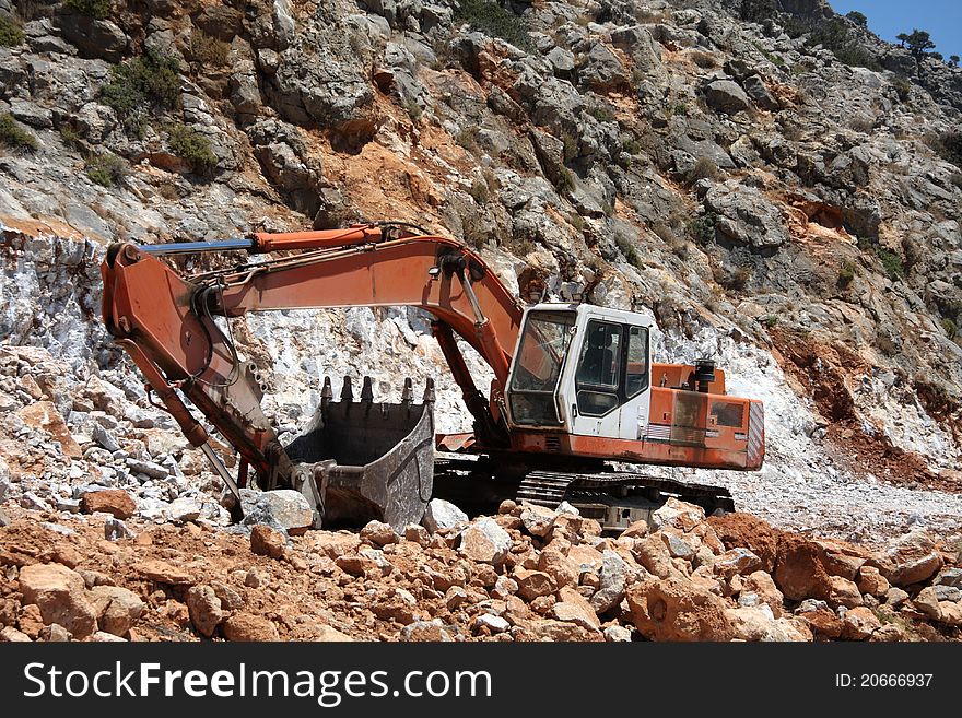 Excavator working on the slope of the quarry