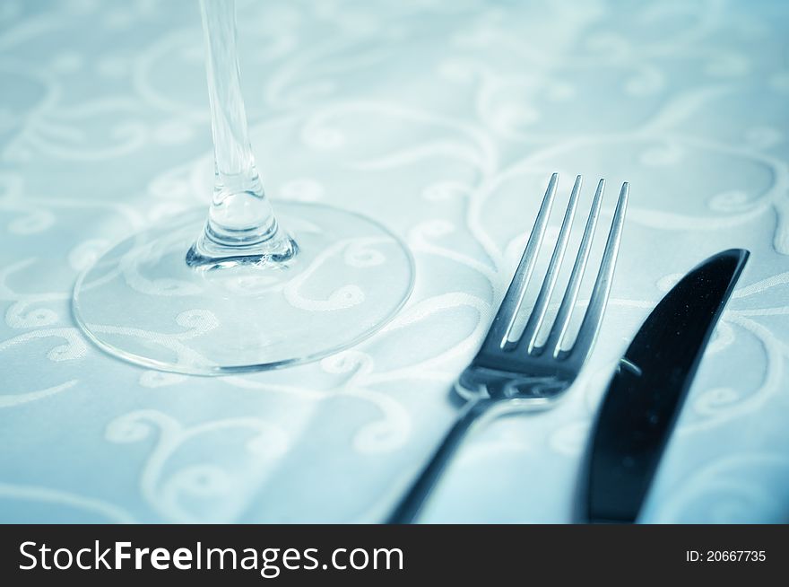 Wineglass on the table with fork and knife.Close up.