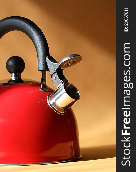 Closeup of red metal kettle on background with sunbeam. Closeup of red metal kettle on background with sunbeam