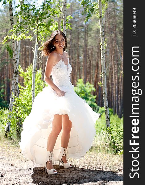 Bride with dark-brown hair posing in forest