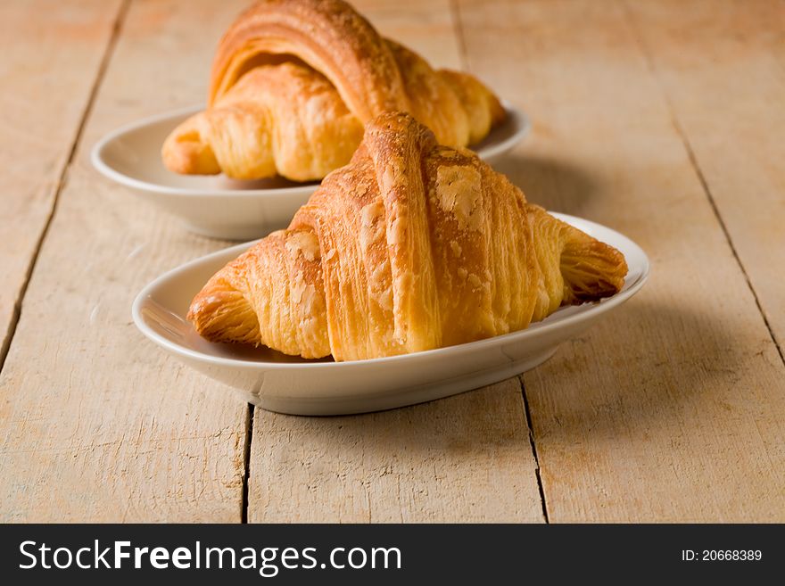 Phot of delicious tasty golden croissants on wooden table