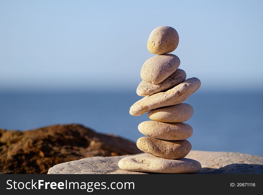 Pile of pebbles in the balance on the seacoast. Pile of pebbles in the balance on the seacoast