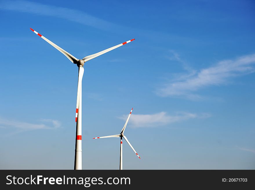 Wind turbine generating electricity on blue sky