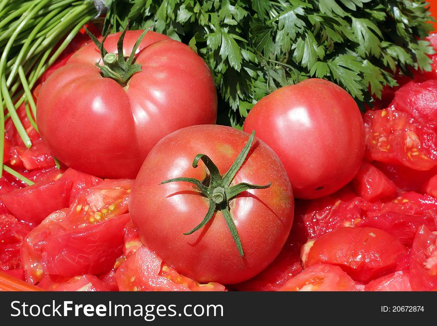 Three tomatoes over chopped tomato mass. Three tomatoes over chopped tomato mass