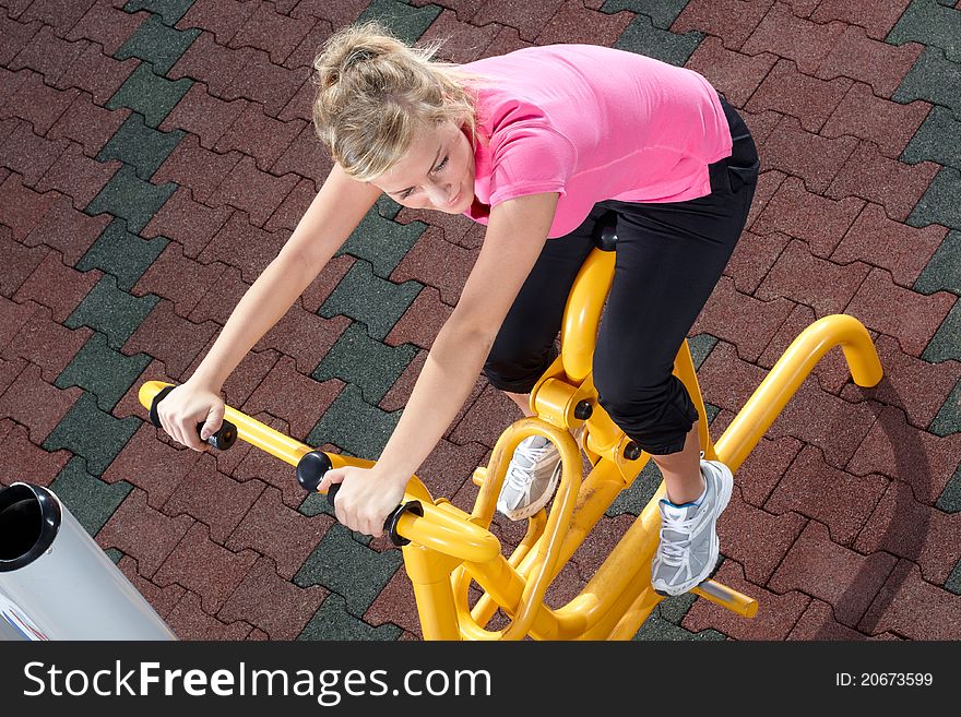 Young woman workout on stepper machine in a park. Young woman workout on stepper machine in a park