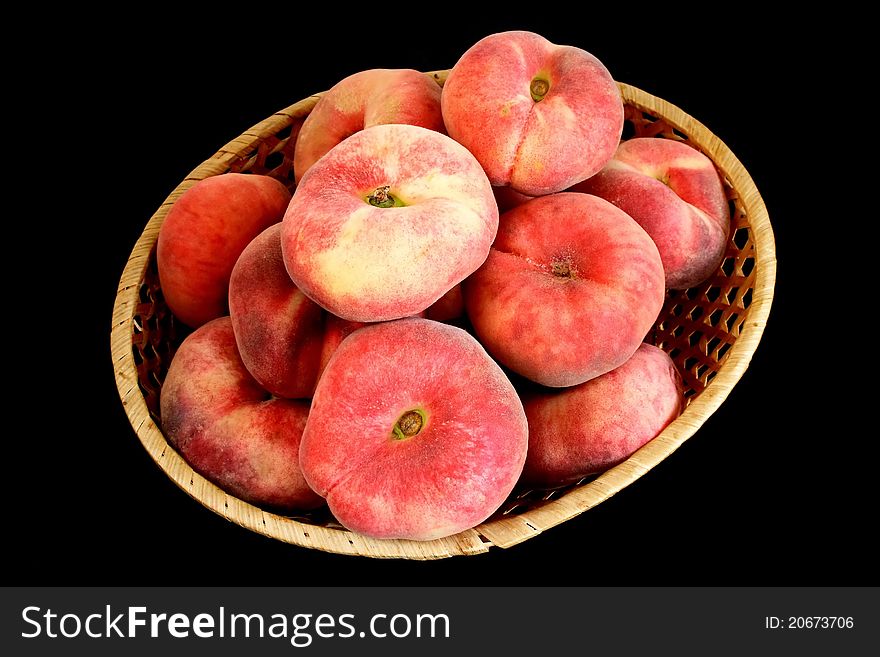 Mountain peach on wicker plate over black background. Mountain peach on wicker plate over black background