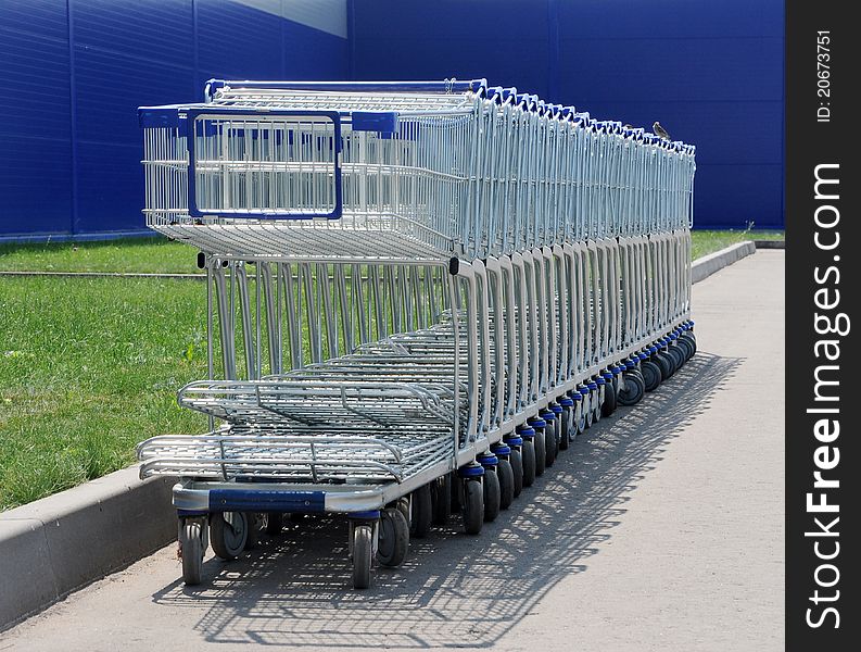Row of white shopping carts in front of a shopping center
