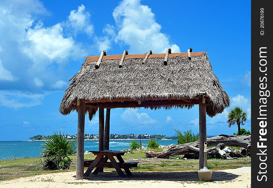 Closeup Of A Thatched Roof Tiki Hut Palapa With An Island In The Background