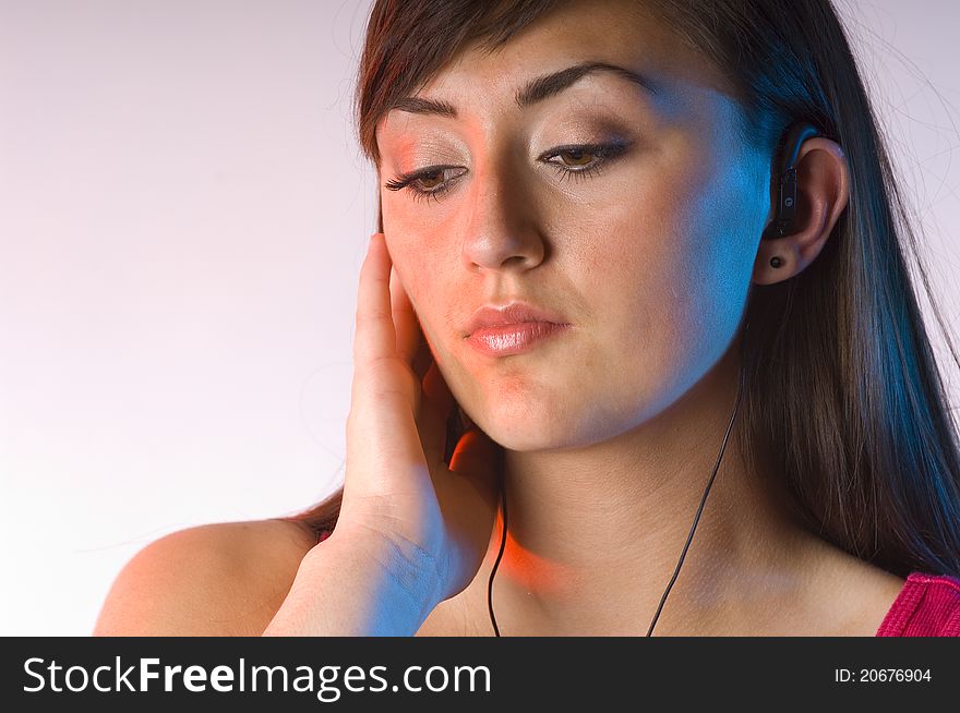 Teen woman listening to music on white