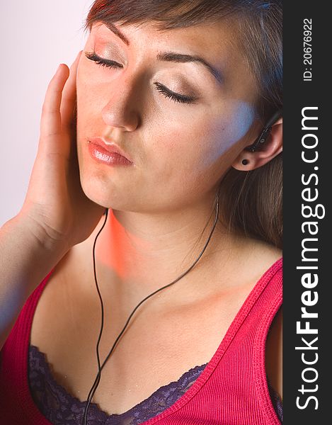 Teen woman listening to music on white with long dark hair and tank top