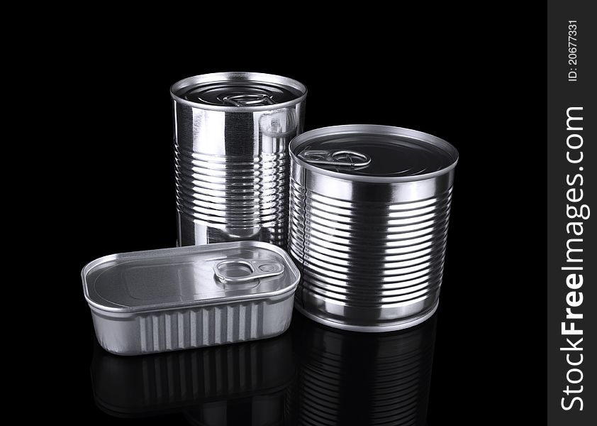 Three different unopened tin cans isolated on black.