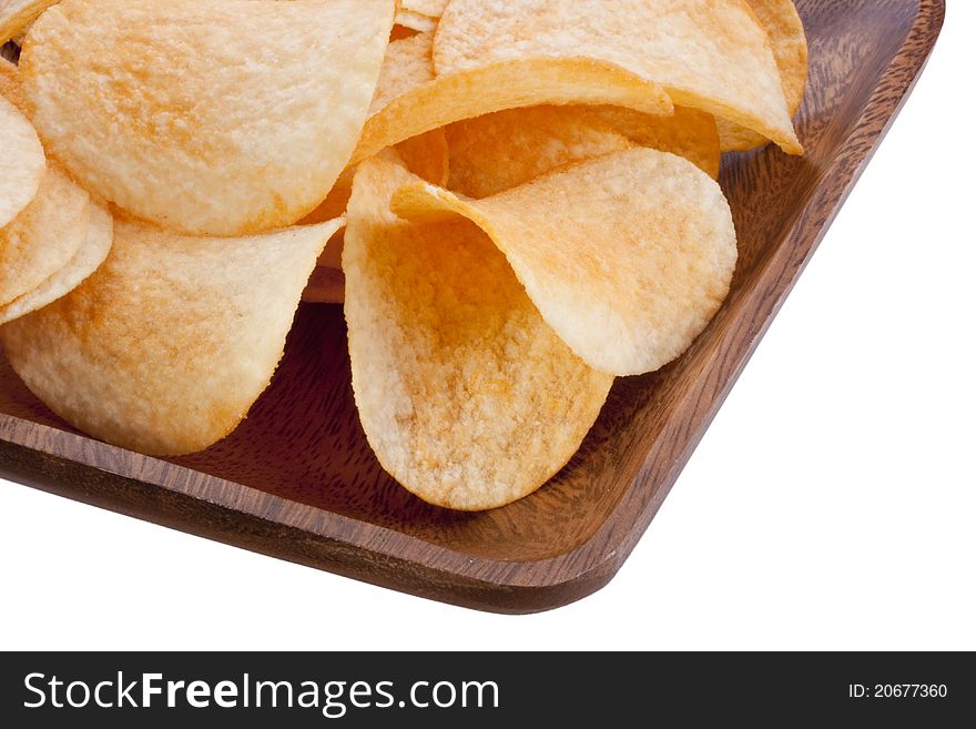 Potato chips from organic products in a wooden plate.