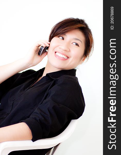Asian woman in black shirt smiling while telephone on white background. Asian woman in black shirt smiling while telephone on white background