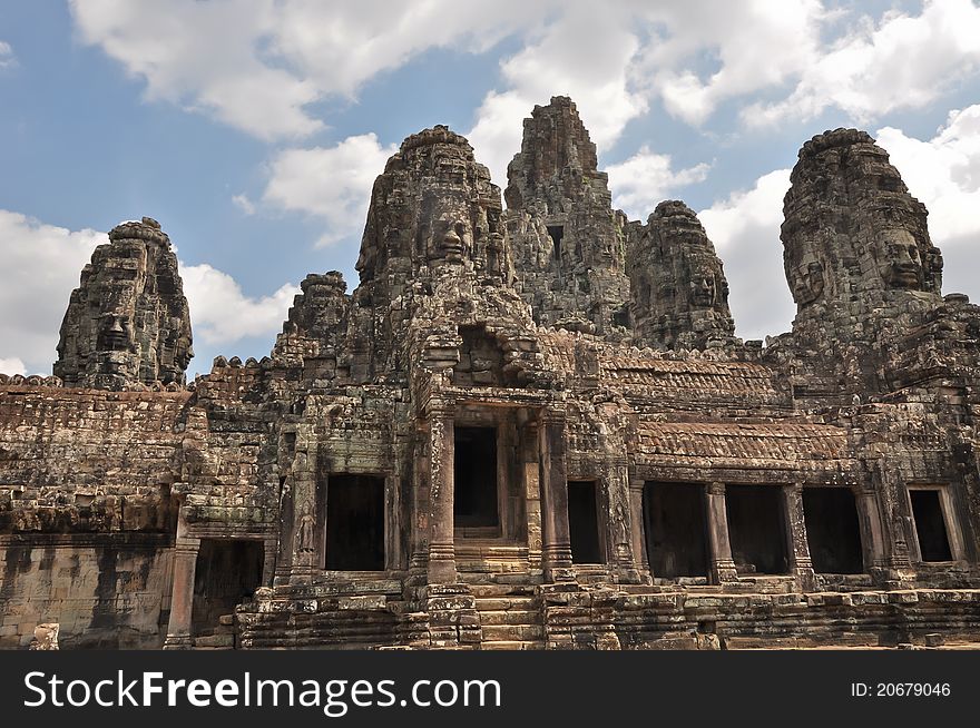 A Bayon Temple with its carved faces, stones and columns.