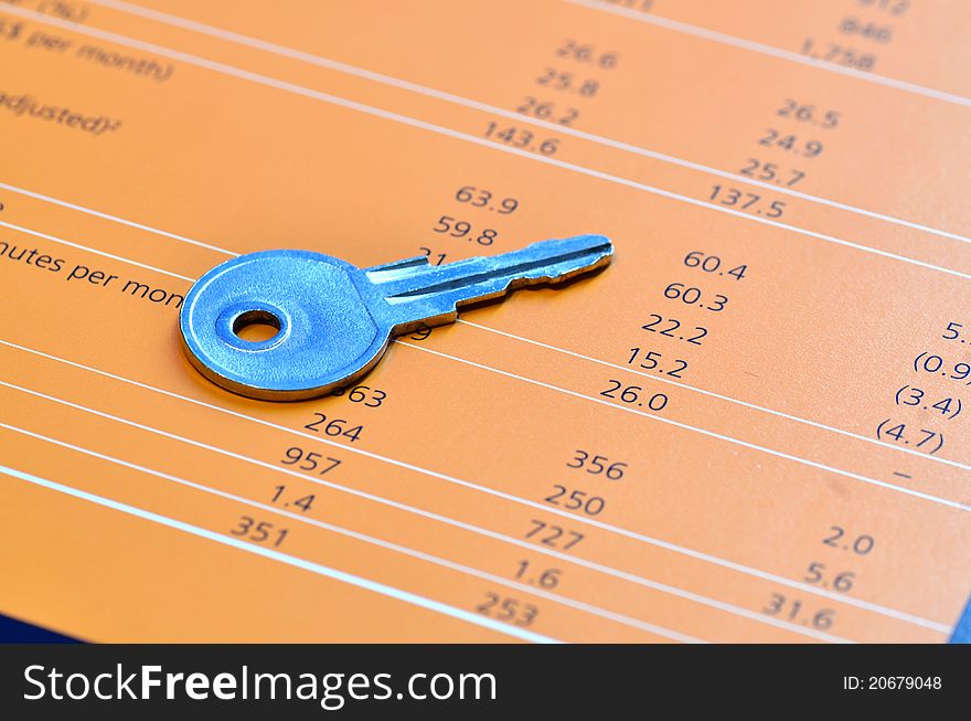 A key on top of a balance sheet. A key on top of a balance sheet.